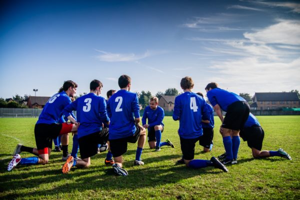 Football team kneeling during training