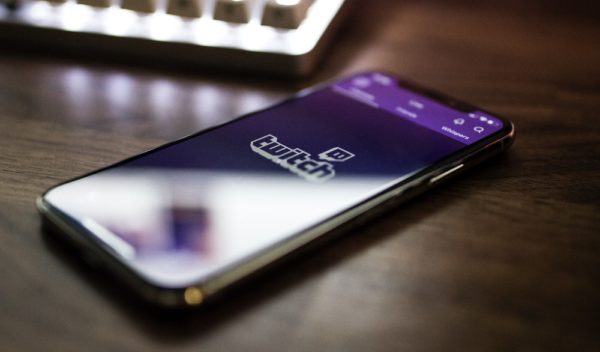 Smartphone on table next to a keyboard.